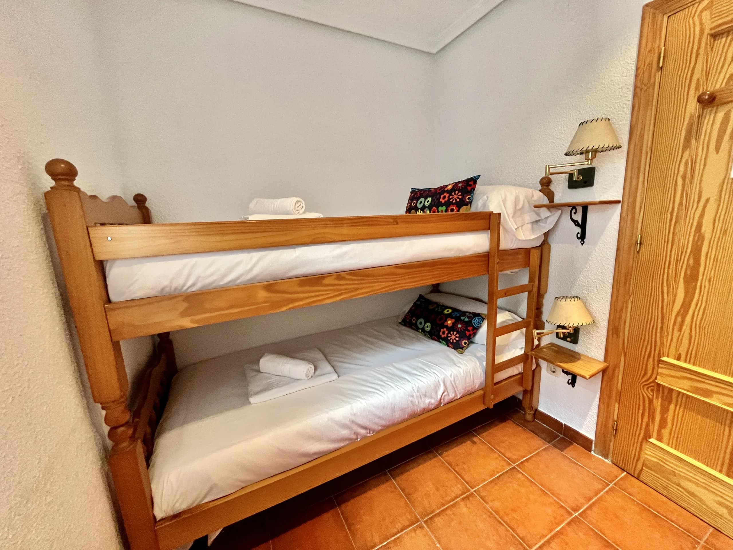 Habitación compartida con literas de madera en la zona hostel